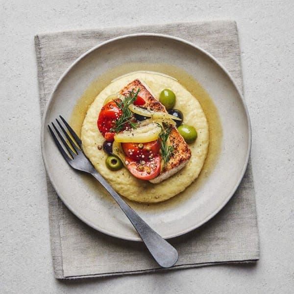 Sicilian Cod alla Ghiotta over Soft Polenta with Olives, Capers and Currants