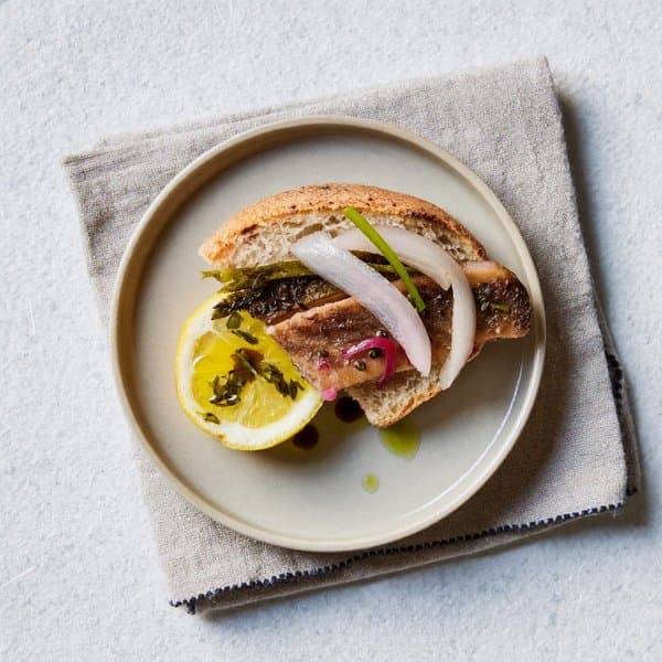 Piemontese Smoked Trout Bite with Quick-Pickled Shallot and Parsley Oil